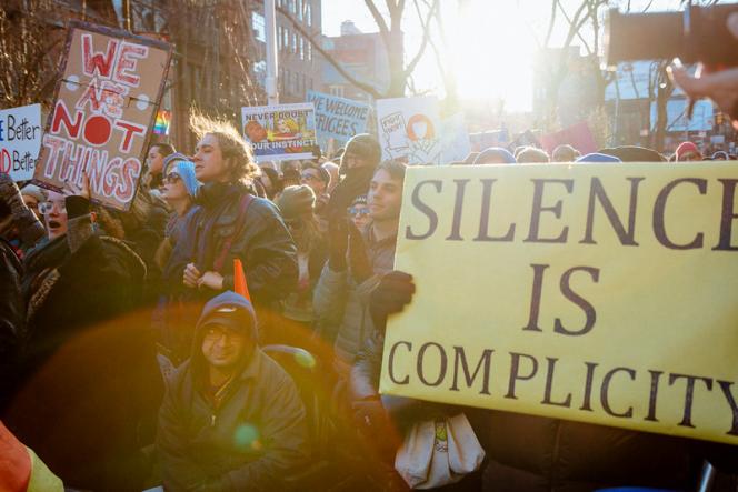 LGBT Solidarity Rally in front of the Stonewall Inn. One poster says "we are not things," and another flag says "Silence is Complicity"