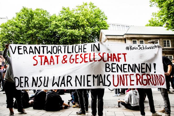 A group holding a white banner that reads:  name those responsible in the state and society! The NSU was never underground