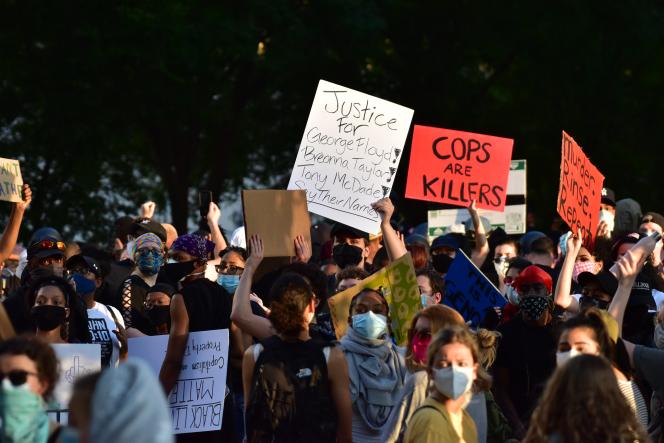 Protesters with fists in the air and holding boards of protest