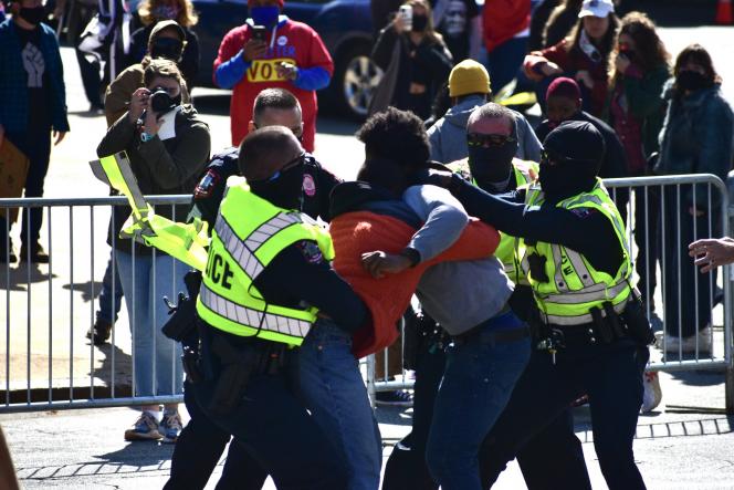 Law enforcement holding back two people