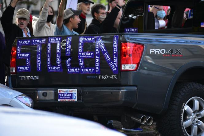 The back of a truck with STOLEN spelled with Trump stickers