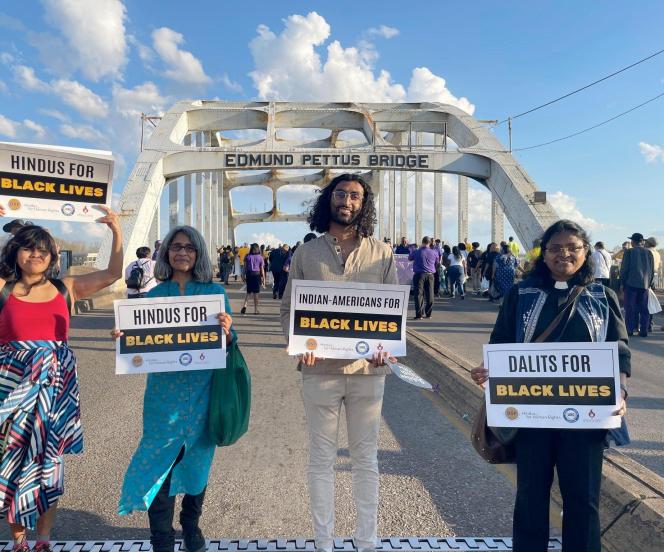 four people holding signs saying "indian-americans for Black lives" and "Dalit for Black Lives"