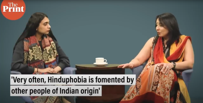 Two women sitting around a coffee table with a cup of coffee on it. The screen says "The Print" on the top left corner and the caption "very often, Hinduphobia is fomented by other people of Indian origin" is at the bottom of the screen.