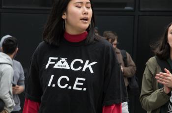 A woman with her eyes closed wearing a black shirt that says "F ck ICE"