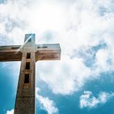 A wooden cross against a blue sky.