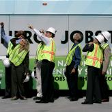 People in hi visibility jackets pointing upwards.