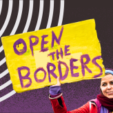 A woman holding a sign that says Open the Borders