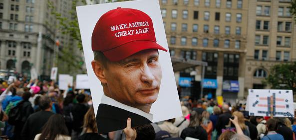 Protest sign of Putin wearing MAGA hat