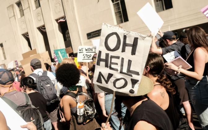 an image of a protest with a sign that says "Oh Hell no!"